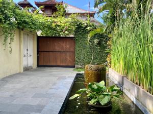 a garden with a koi pond in front of a house at Villa Senan in Seminyak