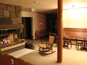 Life is Beautiful - Vacation STAY 94973 في Hachimantai: غرفة معيشة بها موقد وطاولة وكراسي
