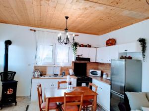 Cozy cottage for 4 في Lávdhas: مطبخ بسقف خشبي وطاولة مع كراسي