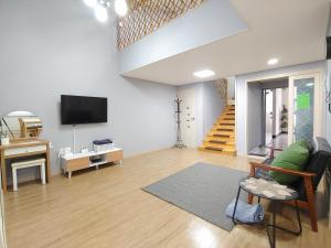 a living room with a couch and a tv at Eutteum-won Pension in Jeju