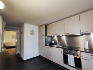 a kitchen with white cabinets and a sink at Appartement tout confort rénové avec vue - Tilleul 5 in Fribourg