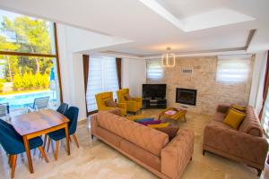 a living room with a couch and chairs and a table at Silver Sami Villa, Özel Havuzlu, Fethiye, in Fethiye