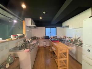 a kitchen with a sink and a wooden counter top at TenTen Guesthouse in Asakusa in Tokyo