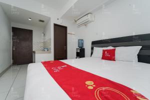 a bedroom with a bed with a red blanket on it at RedLiving Apartemen Mekarwangi Square - Agus 3 Tower A in Bandung