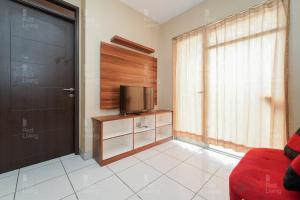 a living room with a television and a door at RedLiving Apartemen Mekarwangi Square - Agus 3 Tower A in Bandung