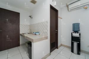uma pequena cozinha com um lavatório e um fogão em RedLiving Apartemen Mekarwangi Square - Agus 3 Tower A em Bandung