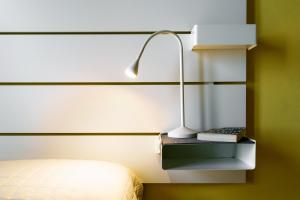 - une chambre avec un lit et une lampe sur un mur dans l'établissement 19 Lodge, à Sienne