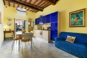 a living room with a blue couch and a kitchen at 19 Lodge in Siena