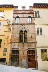 un antiguo edificio de ladrillo con ventanas tapiadas en 19 Lodge en Siena