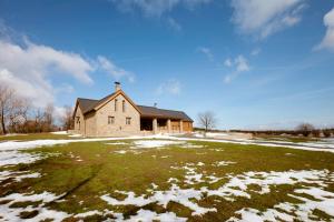 a house in a field with snow on the ground at Lovecká chata VRŠAVA in Koryčany