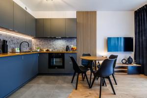 uma cozinha com armários azuis e uma mesa e cadeiras em Apartament Premium em Rzeszów