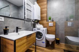 a bathroom with a washing machine and a sink at Apartament Premium in Rzeszów +18 photos