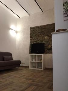 een woonkamer met een bank en een flatscreen-tv bij Bilocale finemente ristrutturato in Letojanni