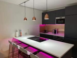 a kitchen with pink and black cabinets and a counter at Luxury 3 pièce Garden Apartment in Cannes Marina in Mandelieu-La Napoule