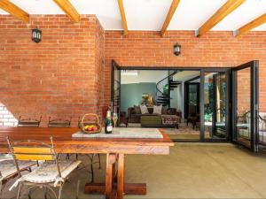 uma sala de estar aberta com uma parede de tijolos em Devon Castle Forest Lodge em Stellenbosch