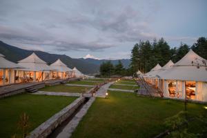 a row of tents with mountains in the background at Tenzinling Luxury Villa Tents in Paro