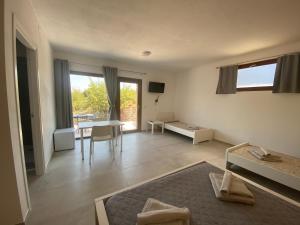 ein Wohnzimmer mit einem Tisch und ein Wohnzimmer mit einem Sofa in der Unterkunft Casa Vacanze Alba in Loceri