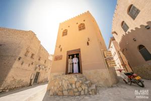 due persone in piedi sulla porta di un edificio di Alaqur View Inn نزل واجهة العقر a Nizwa