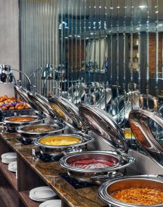 un buffet avec des assiettes de nourriture sur une table dans l'établissement Royal Tulip Hotel & Casino, Tbilisi, à Tbilissi