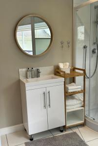 a bathroom with a white sink and a mirror at One Oak Guest House in Somerset West