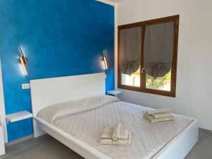 a bedroom with a white bed with a window at Casa Vacanze Alba in Loceri
