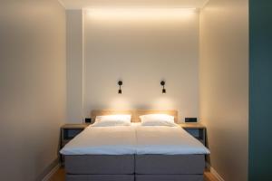 Un dormitorio con una cama con sábanas blancas y luces. en Espak Hostel, en Tallin