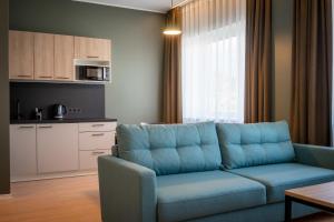 a living room with a blue couch and a kitchen at Espak Hostel in Tallinn