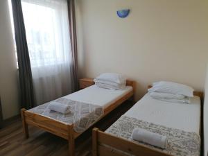 two twin beds in a room with a window at Hotel Ferihegy in Vecsés