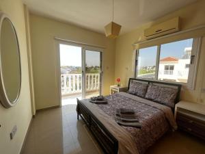 - une chambre avec un grand lit et une grande fenêtre dans l'établissement Sunset Sea View Villa, à Ayia Napa