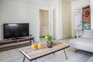 a living room with two wine glasses on a coffee table at Cactus Apartment in Kefallonia