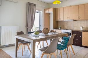 cocina con mesa de madera y sillas en Cactus Apartment en Kefallonia