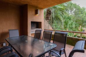 una mesa negra y sillas en un balcón con árboles en San Lameer Villa 3120 - 3 Bedroom Classic - 6 pax - San Lameer Rental Agency, en Southbroom