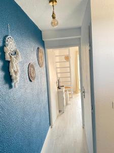 un couloir doté d'un mur bleu avec des plaques. dans l'établissement Bella vista ,accès direct plage, front de mer, vue mer panoramique, au Barcarès