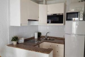 セビリアにあるEnjoy Life Apartments Sevillaの白いキッチン(シンク、冷蔵庫付)