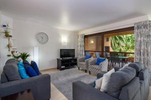 sala de estar con 2 sofás y TV en San Lameer Villa 3120 - 3 Bedroom Classic - 6 pax - San Lameer Rental Agency, en Southbroom
