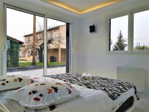 um quarto com uma cama e uma grande janela em Magnifique maison moderne et atypique au mobilier italien - quartier Sapiac - Piscine et parking privés gratuits - Climatisation em Montauban