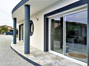 uma casa com grandes janelas de vidro e um poste em Magnifique maison moderne et atypique au mobilier italien - quartier Sapiac - Piscine et parking privés gratuits - Climatisation em Montauban