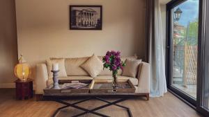 sala de estar con sofá y mesa con flores en Hotel Passport Tbilisi, en Tiflis