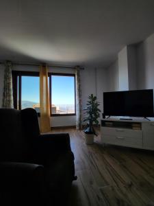 a living room with a flat screen tv and a couch at Apartamento Beck- Tierra in Soportújar