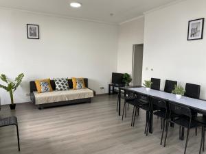 uma sala de estar com um sofá, mesas e cadeiras em Apartments Plantin 3 sleeping rooms 2 bathrooms. em Antuérpia