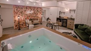 a large tub in a room with a living room at Suite romantique avec Jacuzzi - Hypercentre, Comédie in Montpellier