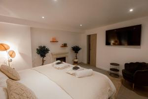 a bedroom with a white bed and a tv on the wall at Suite romantique avec Jacuzzi - Hypercentre, Comédie in Montpellier