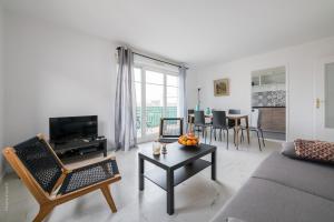 ein Wohnzimmer mit einem Sofa und einem Tisch in der Unterkunft Les 2 Lys in Brétigny-sur-Orge