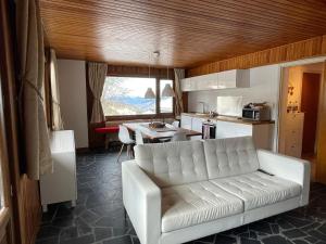 a living room with a white couch and a kitchen at Lovely Apt Chalet Courchevel 1650 in Courchevel