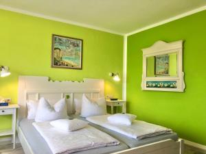 a green bedroom with two beds with white pillows at Haus am Kurpark in Schömberg