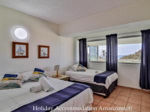 a bedroom with two beds and a window with a view at Holiday Accommodation Amanzimtoti in Amanzimtoti