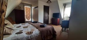 a bedroom with a large bed and a chair at lamaisonmelidine in Saint-Mards-de-Blacarville