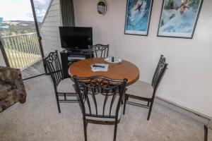 a dining room table with chairs and a television on a balcony at ML332 1BR1BA Slope View WiFi Parking Village in Snowshoe
