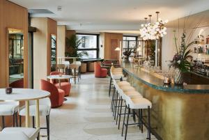 un bar dans un restaurant avec des tables et des chaises dans l'établissement Small Luxury Hotel Ambassador Zurich, à Zurich