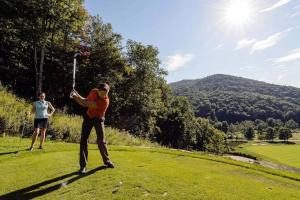 two people playing golf on a golf course at ML332 1BR1BA Slope View WiFi Parking Village in Snowshoe